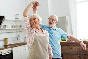 Life Assure Senior Woman Sitting In Chair And Laughing With Caregiver Nurse Blog